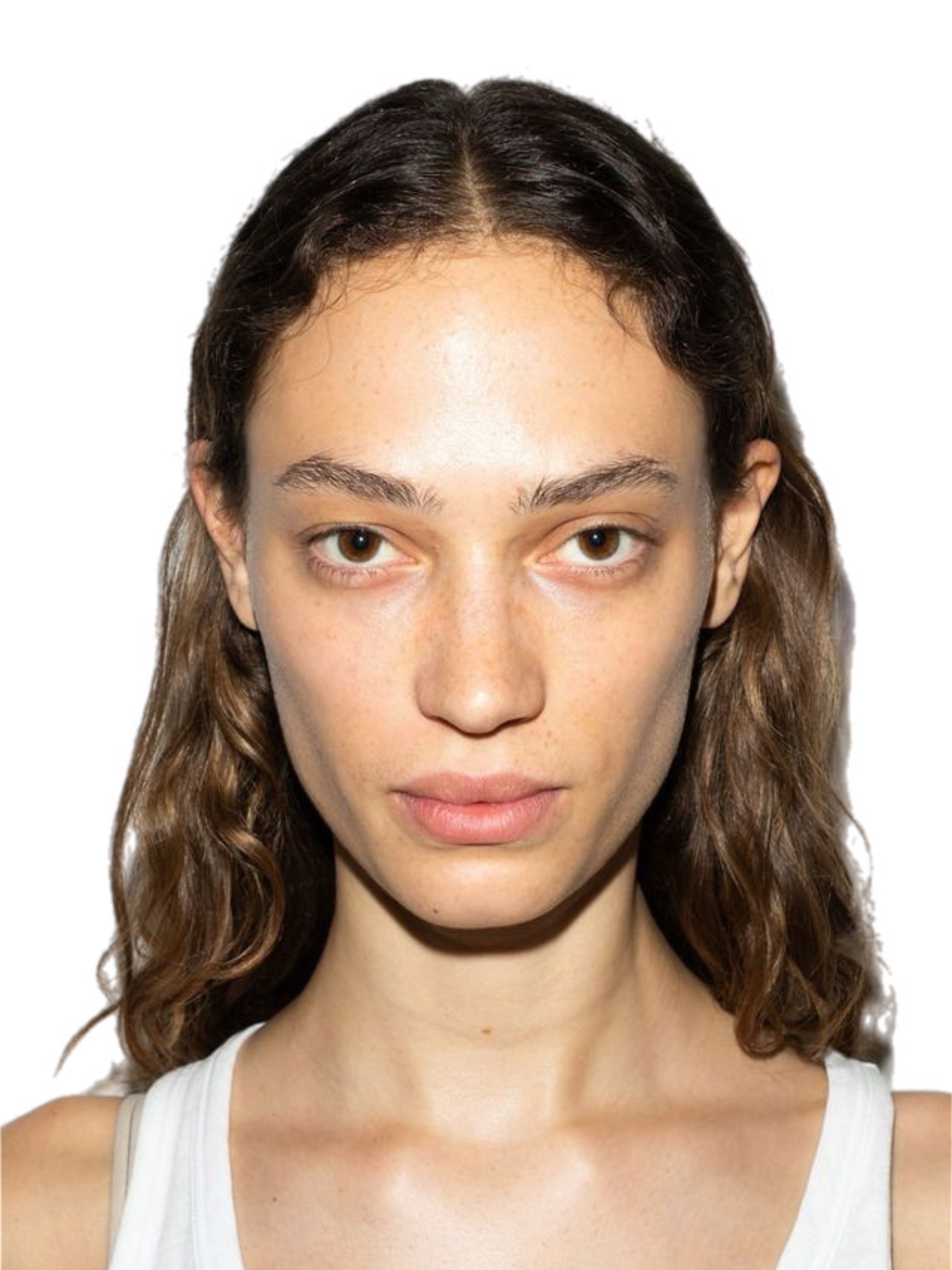 Androgynous Indian model with voluminous black hair, chunky gold creole earrings, cream tank top, natural glowing skin